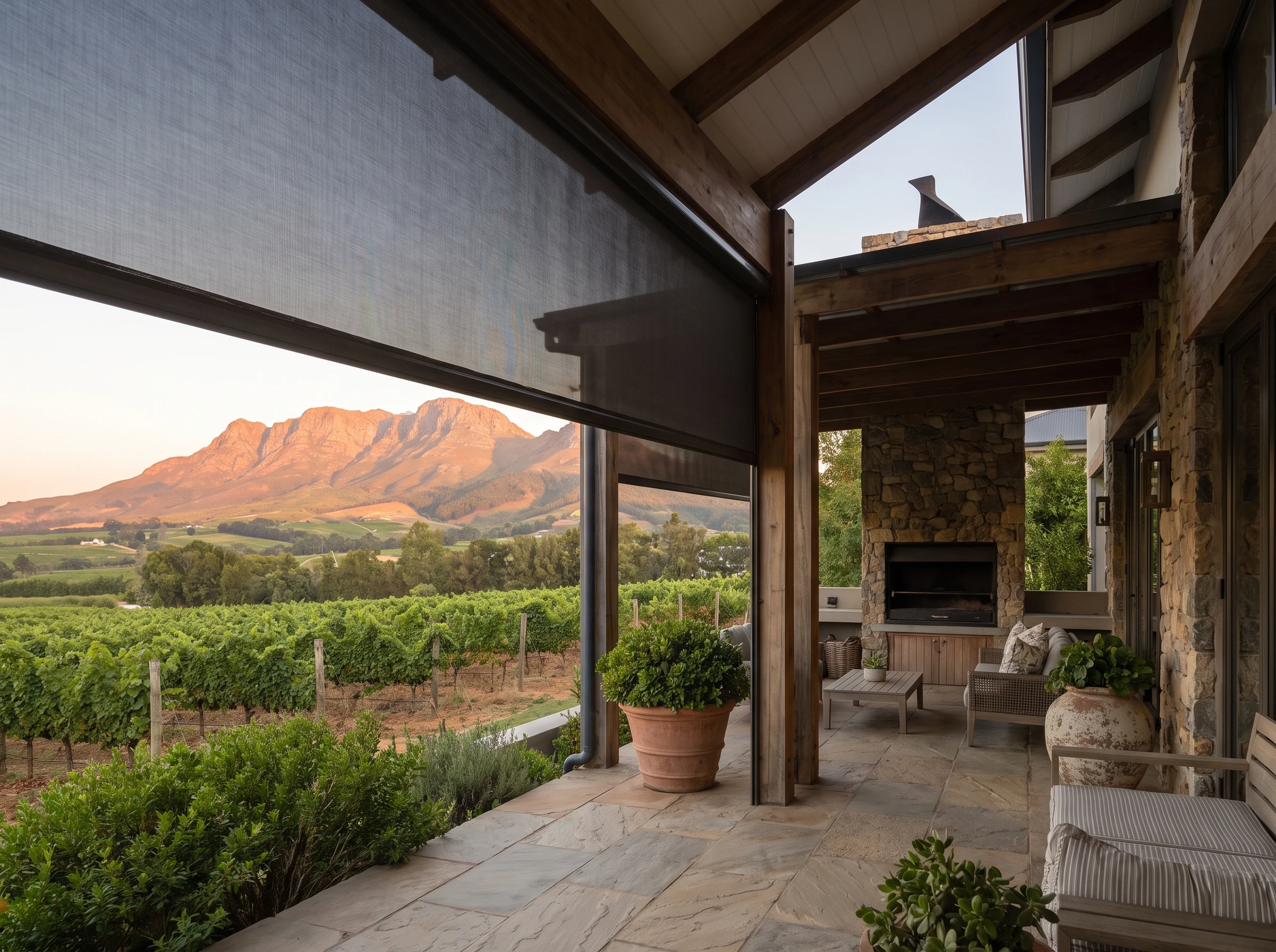 Motorised zip screen on the terrace of a Stellenbosch wine and golf estate home, mountain visible beyond vineyard rows